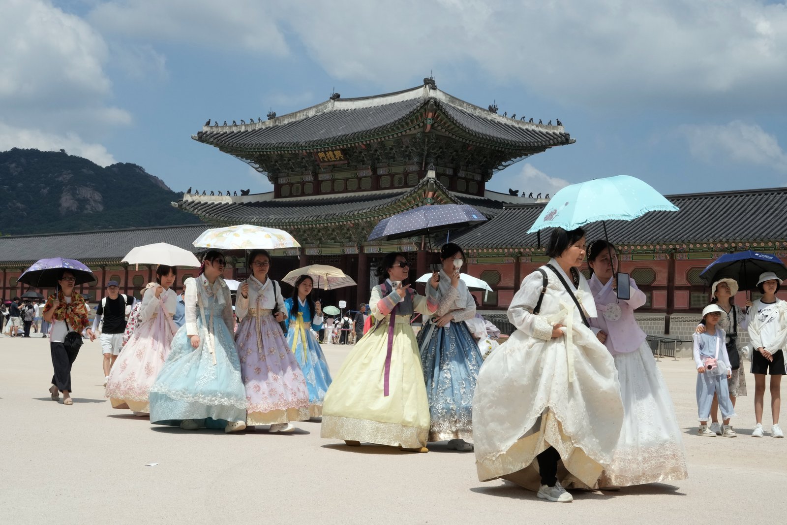 Visitors holding umbrellas leave the Gyeongbok Palace